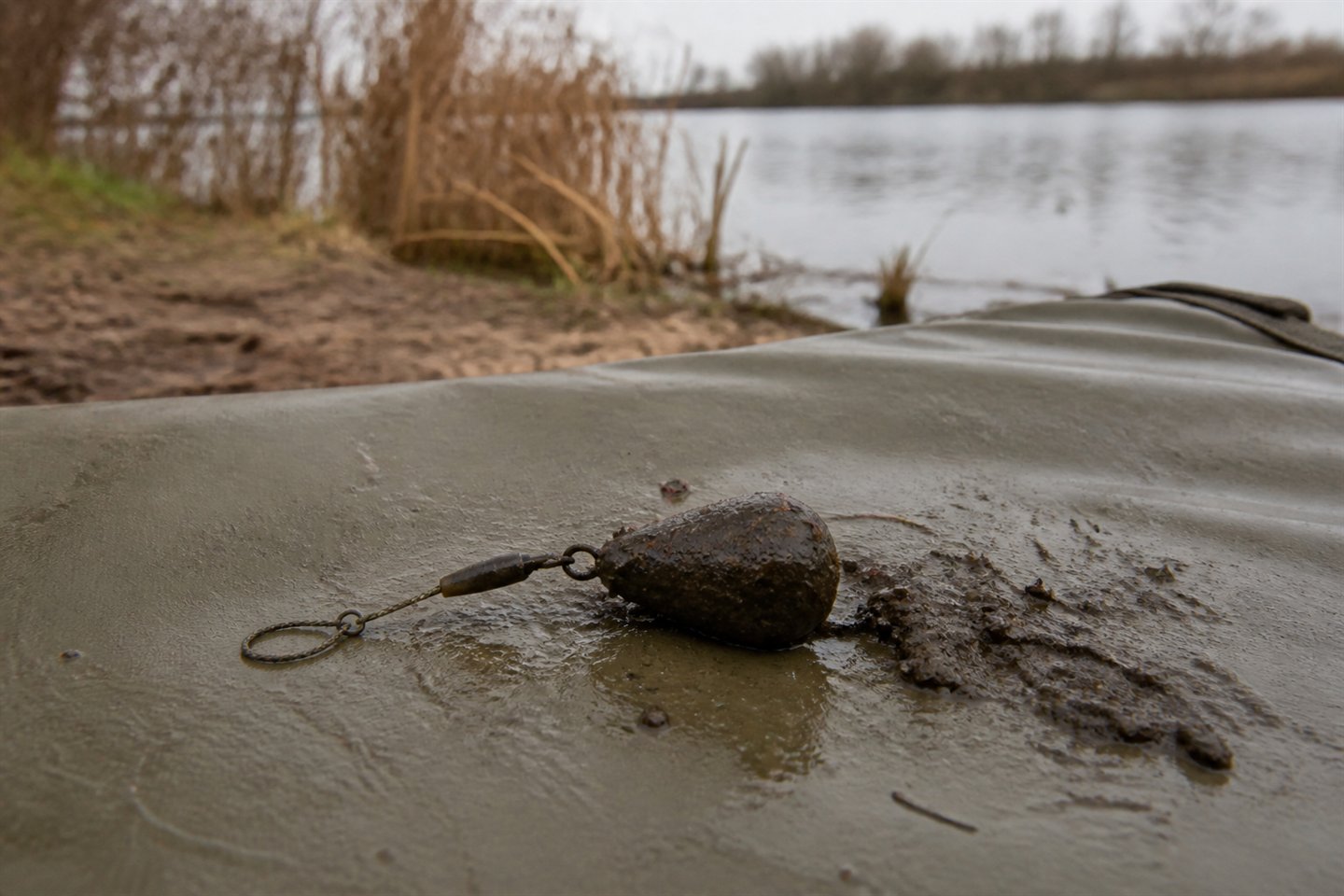 A marker lead freshly retrieved with dark lakebed silt and fine natural debris