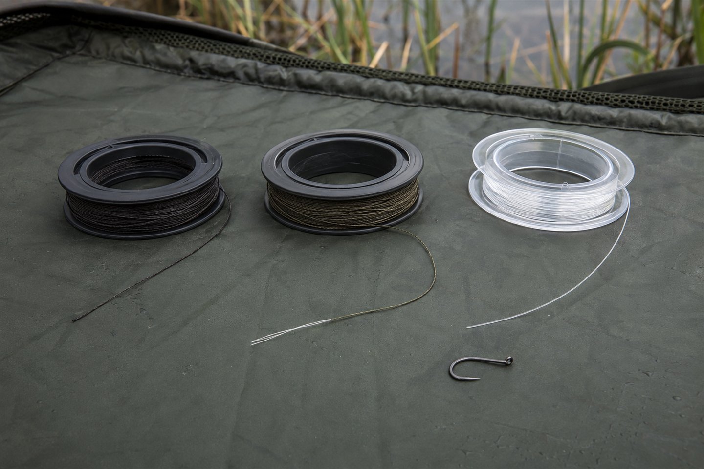 Braid, coated braid and fluorocarbon carp hooklink materials arranged beside a loose hook