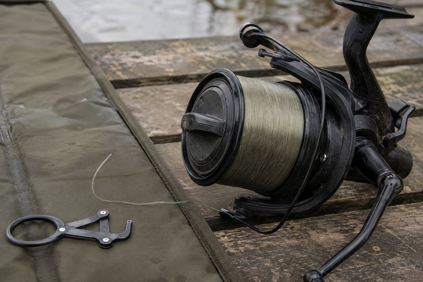 A big-pit carp reel evenly loaded with olive monofilament main line
