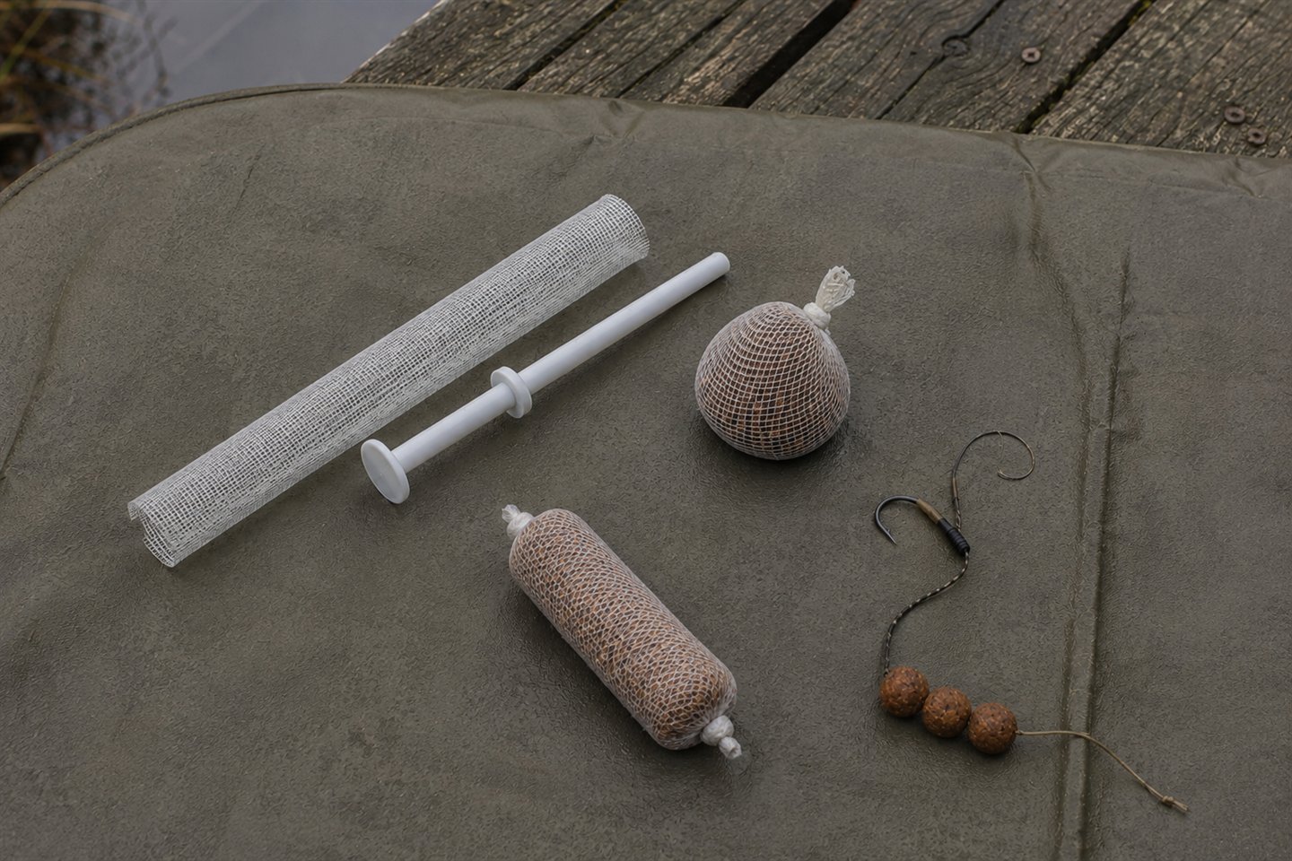 Dry PVA mesh tube, bait parcels and stringer arranged beside a carp rig